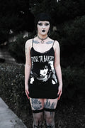 Person wearing a black tank top with graphic design and text, standing outdoors.